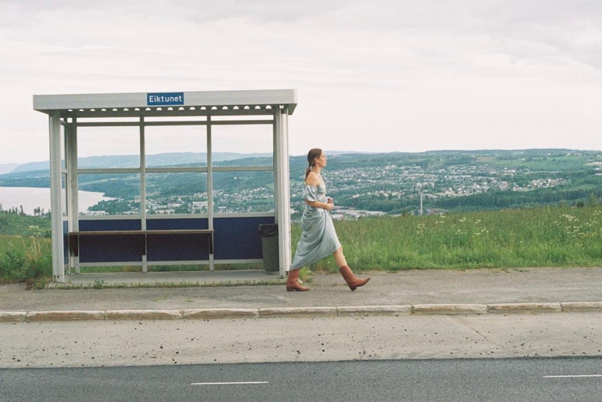 Anna of the North walking past bus stop for Crazy Life album announce
