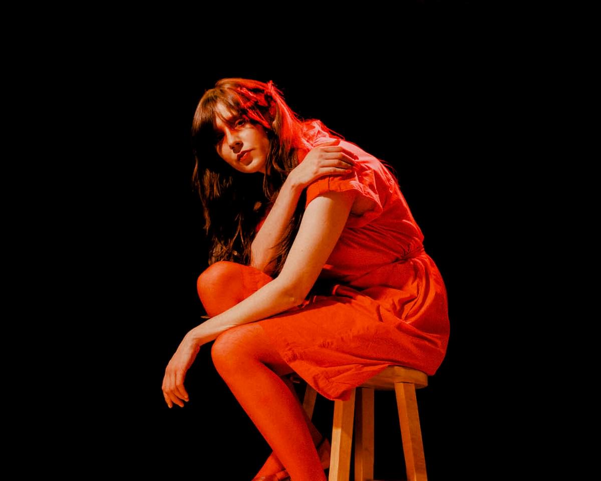 Circuit des Yeux red outfit on stool