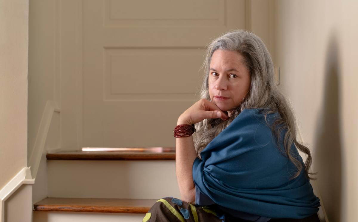 Natalie Merchant sitting on some stairs outside of a childs bedroom
