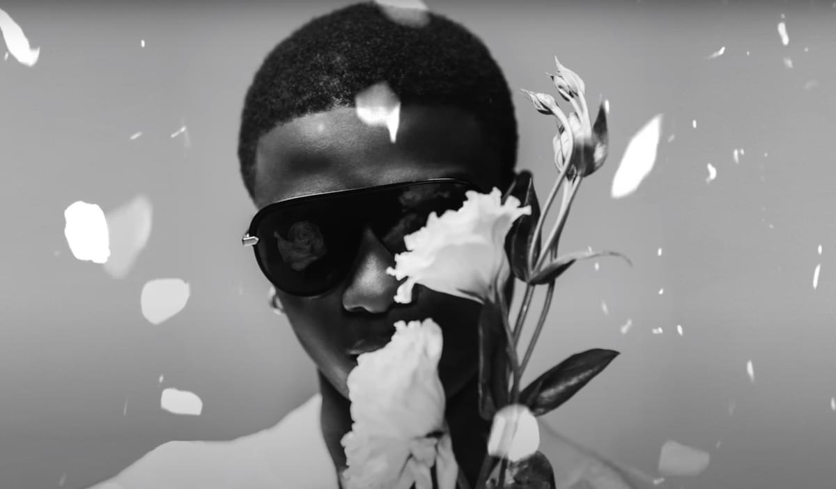 Wizkid holding flowers with falling petals for "Bad To Me" single