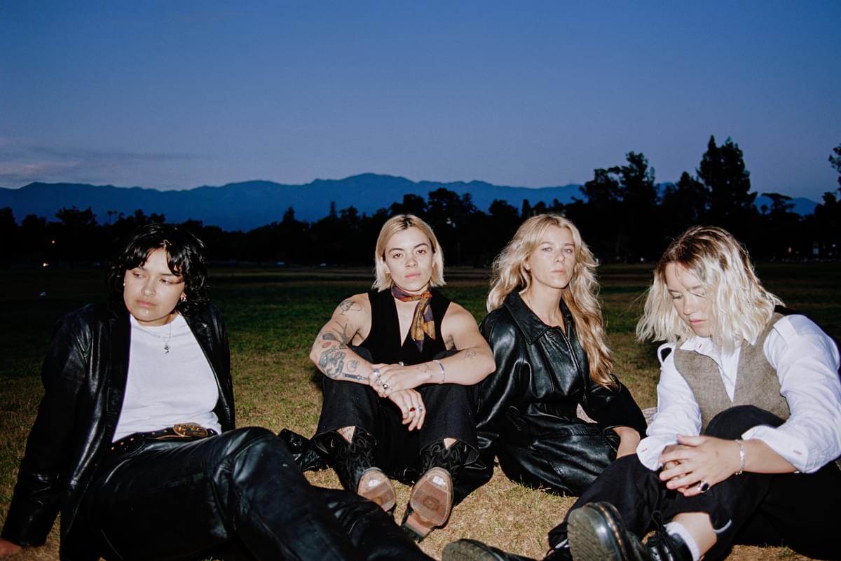 The Aces sitting on grass at dusk for "Girls Make Me Wanna Die" No Rome remix